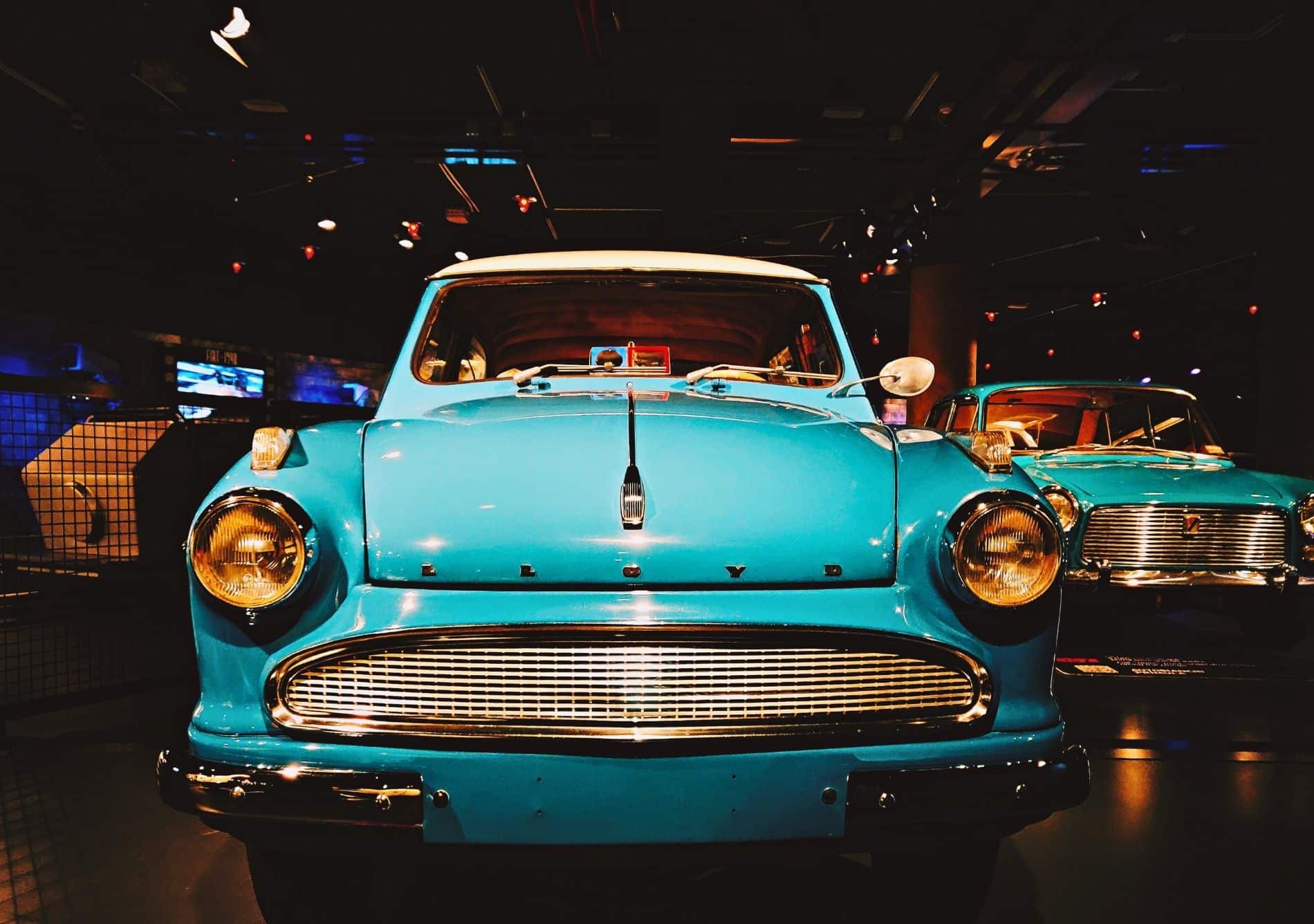 blue vintage cars on display in indoor showroom 