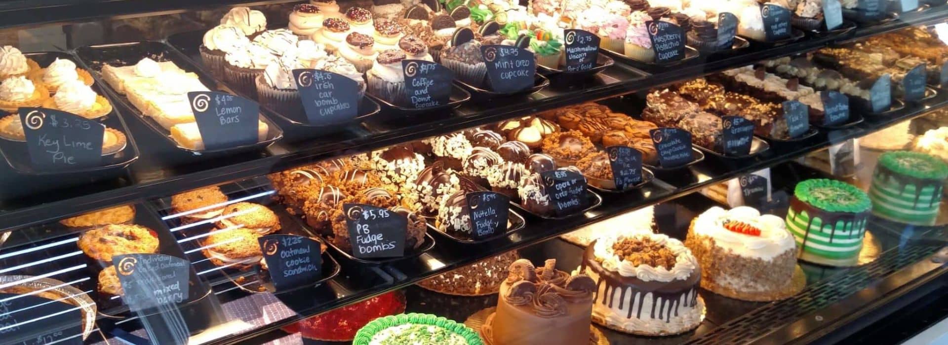 Glass display case with shelves of decadent desserts