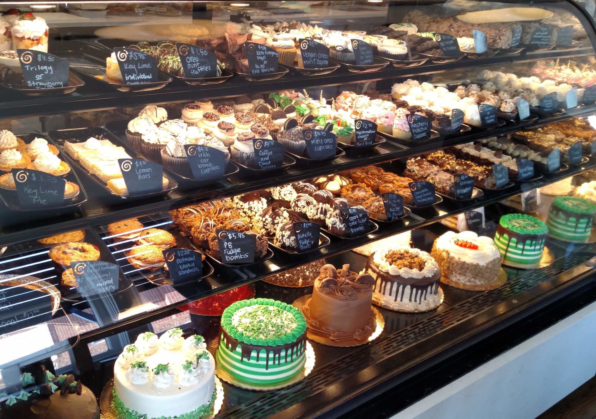 Glass display case with shelves of decadent desserts