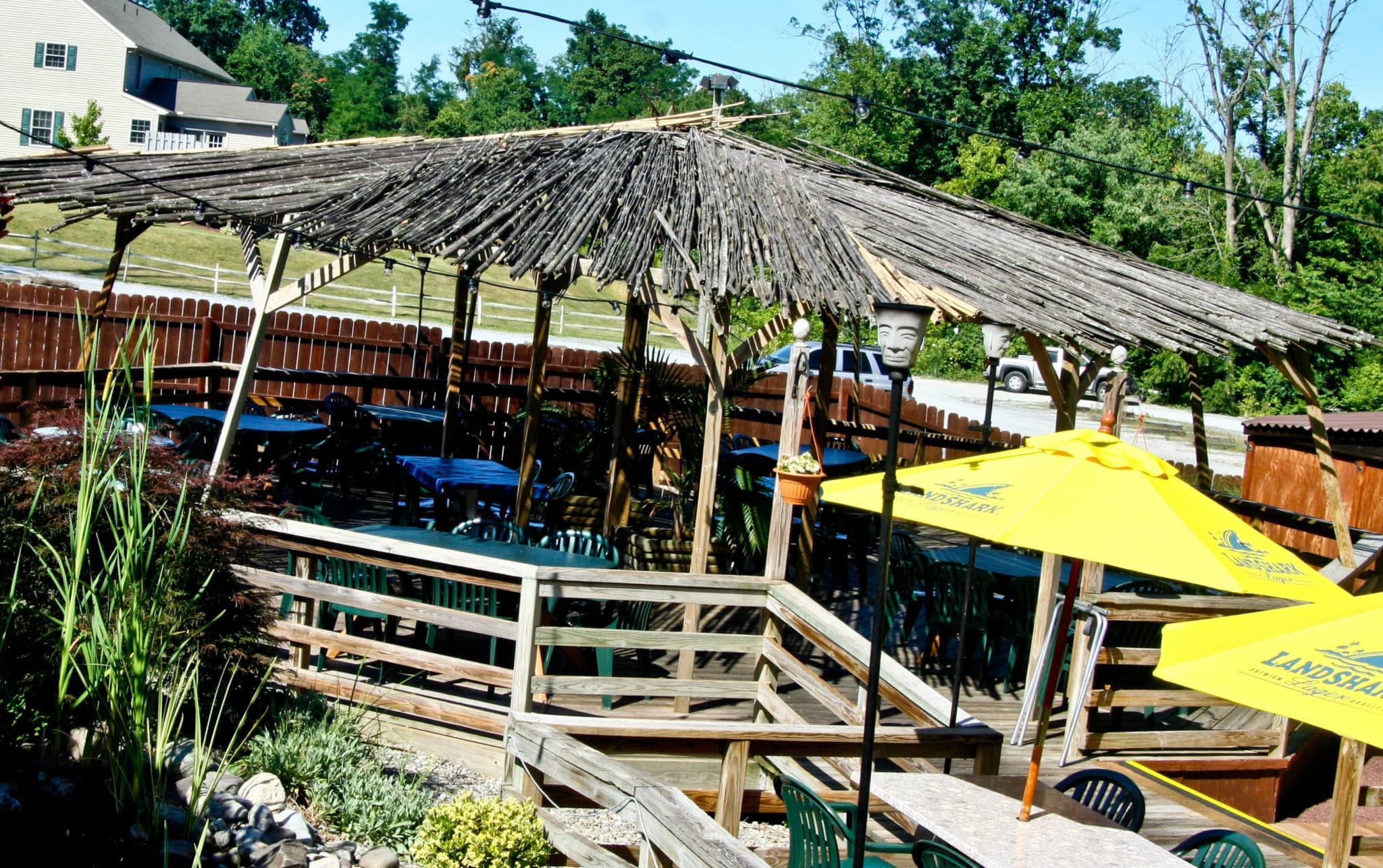 covered deck seating area with many tables and chairs