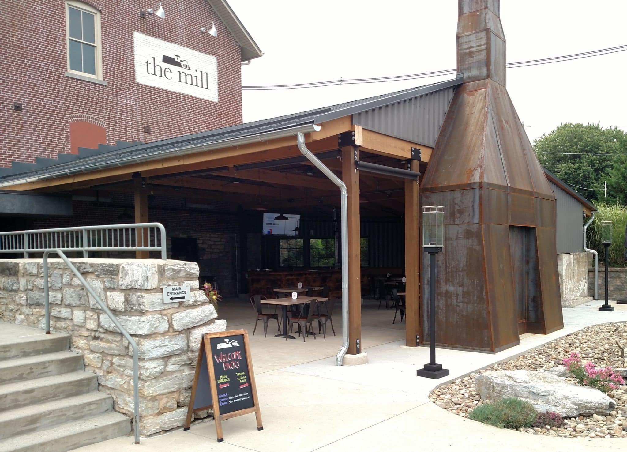 outdoor dining section showing a covered roof with fireplace