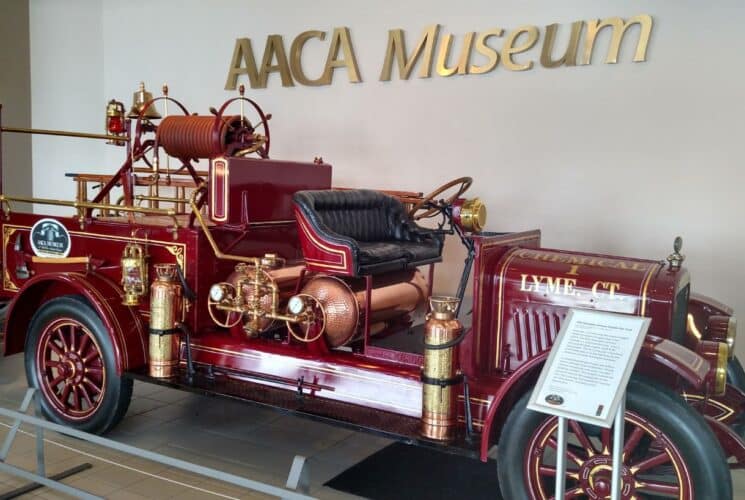 A historic red and gold firetruck sitting in a museum