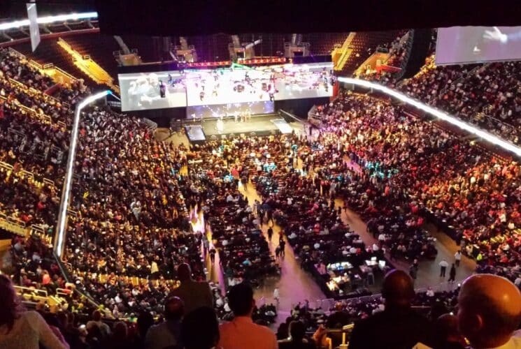 Large indoor arena full of people attending an event