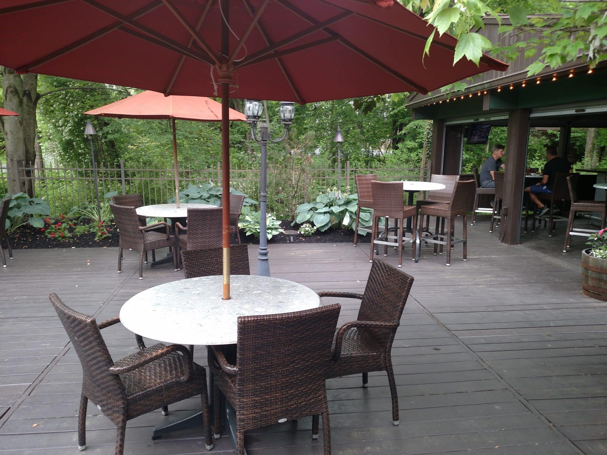 the deck of the hide a way showing covered tables and chairs